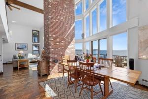 a dining room with a table and chairs with a view of the ocean at Clark Point Cottage, ocean access, panoramic views in Clark Island