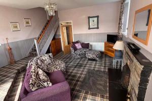 a living room with a purple couch and a staircase at Apartment Sleeps 2 with WiFi in Wick
