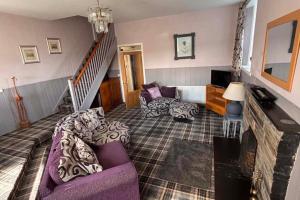 a living room with a purple couch and a staircase at Apartment Sleeps 2 with WiFi in Wick