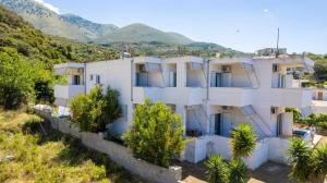 a white house with mountains in the background at Nefeli apartments in Borsh