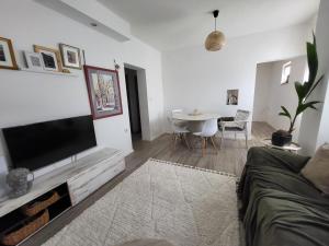 a living room with a flat screen tv and a table at Garden in Šibenik