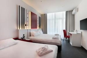 a hotel room with two beds and a desk at Vegas Resort in St. Julianʼs +69 photos
