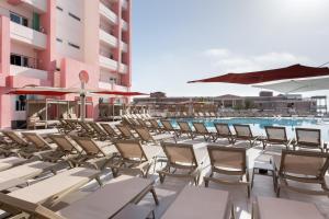 a row of chairs and umbrellas on a swimming pool at Vegas Resort in St. Julianʼs