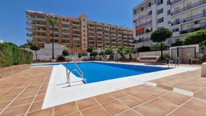 a swimming pool in front of a building at Apartamento Fuengirola Costa in Fuengirola