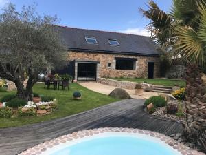 a stone house with a swimming pool in front of it at Chambres D'Hotes L'Atipic in Saint-Brieuc