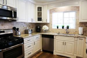 a white kitchen with white cabinets and a window at Lavish 5 Bedroom, 4 Bath Pool Home 3/4 Mile To Disney in Anaheim