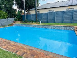 a swimming pool with blue water in front of a house at House 22 on Alice in Centurion