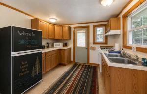 a kitchen with a black refrigerator and a sink at A Shore Thing: Beach Access in Saint Germain