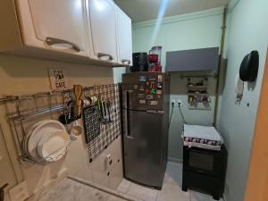 a small kitchen with a refrigerator and a sink at Apartamento Mobiliado - Botafogo in Rio de Janeiro