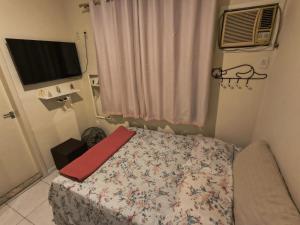 a small bedroom with a bed and a television at Apartamento Mobiliado - Botafogo in Rio de Janeiro