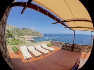 a view of the ocean from a balcony with chairs at Torre Turbolo Apartments in Massa Lubrense