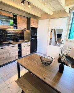 a kitchen with a wooden table in a room at L'Ô de Sciez in Sciez
