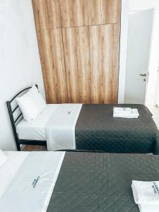 a bedroom with two beds and a wooden door at Hotel Galini Polychrono in Polychrono