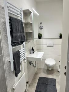 a white bathroom with a sink and a toilet at Jagsttalglück in Neudenau