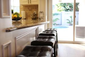 a row of stools sitting at a bar in a kitchen at Lavish 5 Bedroom, 4 Bath Pool Home 3/4 Mile To Disney in Anaheim