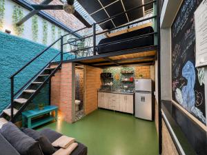a loft conversion with a green floor and a staircase at La Gruta Coliving in Medellín