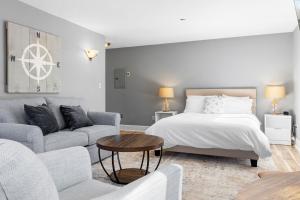 a white bedroom with a bed and a couch at Mabel's Maine Studio on the River in Edgecomb