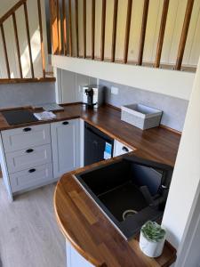 a kitchen with a wooden counter top with a sink at Kniveton Wood Hut in Ashbourne