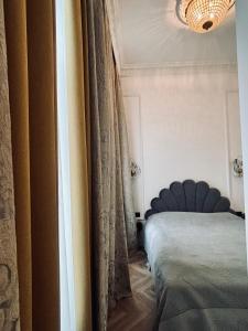 a bedroom with a bed and a curtain at The Gediminas Residence in Vilnius