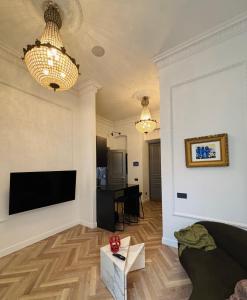 a living room with a couch and a flat screen tv at The Gediminas Residence in Vilnius