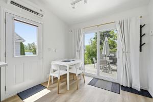 a white room with a white table and a sliding glass door at The Birch in Wellington