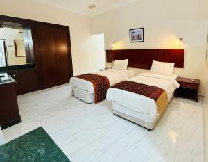 a hotel room with two beds in a room at Al Barka Palace Hotel in Ma‘ābīlah
