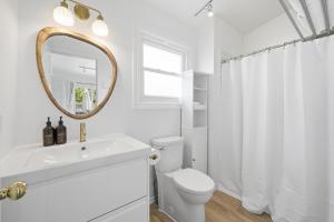 a white bathroom with a toilet and a mirror at The Birch in Wellington +30 photos