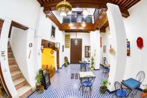 a room with tables and chairs and a ceiling at Dar Mayssa Fez in Fez