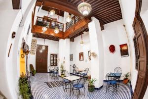 a room with chairs and tables and a ceiling at Dar Mayssa Fez in Fez