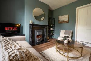 a living room with a fireplace and a mirror at Old Lumford Cottage, Bakewell - Picturesque Riverside Property in Bakewell