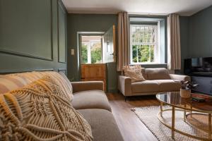 a living room with a couch and a tv at Old Lumford Cottage, Bakewell - Picturesque Riverside Property in Bakewell +40 photos