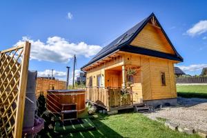 a small wooden house with a black roof at Domek u Hanci Pod Gubałówką z Jacuzzi in Ząb
