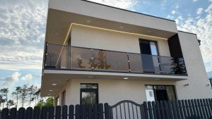 a building with a balcony on the side of it at Alisa's apartments Ureki in Ureki
