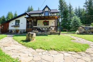 a house with a stone path in front of it at Doru' Bucovinei in Moldoviţa