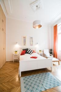 ブダペストにあるAnker Apartment at Deák Sq.の白いベッドルーム(白いベッド1台、青いラグ付)