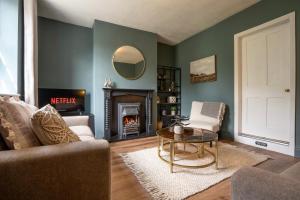 a living room with a couch and a fireplace at Old Lumford Cottage, Bakewell - Picturesque Riverside Property in Bakewell