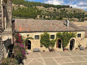 an old stone building with a bench in a courtyard at Agriturismo Feudo Tudia in Resuttano