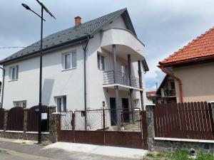 a white house with a gate and a fence at Casa Crisan in Topliţa