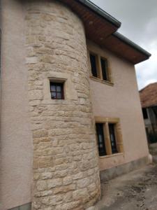 a stone building with a window on the side of it at gite La Tour Au Comté in Charency