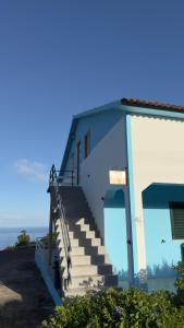 a stairway leading to a building with the ocean in the background at Santo Cristo Loft in Lajes das Flores
