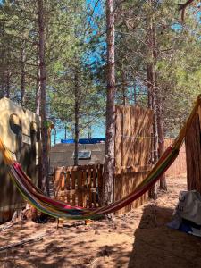 a hammock in the woods next to a fence at Каравана Кукер in Sozopol
