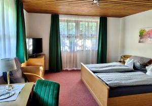 a bedroom with a bed and a table and a window at Frühstück Pension by Anna in Rattenberg