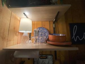 a shelf with a lamp and dishes on it at Hill Country Cabin 2 in Canyon Lake
