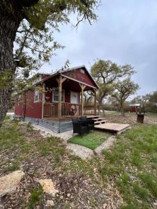 a red cabin with a porch and a deck at Hill Country Cabin 3 in Canyon Lake +14 photos