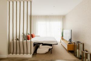 a bedroom with a bed and a large window at Shellter Apartments by the sea in Vieira de Leiria