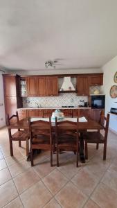 a dining room with a table and chairs and a kitchen at Casa Manchia in Loiri +6 photos