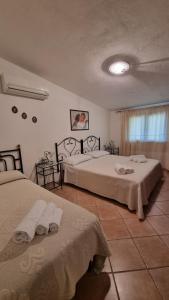 a bedroom with two beds and a window at Casa Manchia in Loiri
