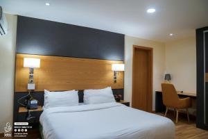 a hotel room with a large bed and a desk at Sabah Resort Nouakchott in Nouakchott