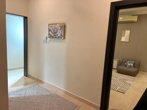 a hallway with a couch and a painting on a wall at Stylish 2BR Escape Near Muscat City Centre in Mawāliḩ +188 photos