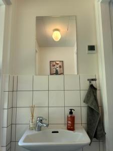 a bathroom with a sink and a mirror at Sommerhus i Hals in Hals